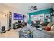 Spacious living room with a large television, comfortable seating, and modern decor at 7717 Pine Warbler Way, North Las Vegas, NV 89084