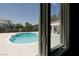 Backyard pool and patio viewed through a window at 7745 Radcliff St, Las Vegas, NV 89123