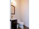 Powder room with dark cabinets, a gold faucet, and a wood-framed mirror at 7745 Radcliff St, Las Vegas, NV 89123