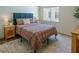 Well-lit bedroom with a blue headboard, patterned bedding, and side tables at 7745 Radcliff St, Las Vegas, NV 89123