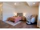 Bright bedroom boasts wood look flooring, a massage chair, and a large bed with an upholstered headboard at 7745 Radcliff St, Las Vegas, NV 89123