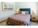 Bedroom with a blue headboard, patterned bedding, and side tables at 7745 Radcliff St, Las Vegas, NV 89123
