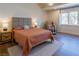 Spacious bedroom features wood look flooring, large window, massage chair, and a large bed with an upholstered headboard at 7745 Radcliff St, Las Vegas, NV 89123
