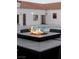Close up of a modern gas fire pit with custom tile on an outdoor entertaining table at 7745 Radcliff St, Las Vegas, NV 89123
