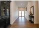 Long hallway with wood flooring, dark wood decorations, and a view of the entry doors at 7745 Radcliff St, Las Vegas, NV 89123