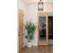 Hallway with wood flooring, plant in white pot, and glass door to another room with books at 7745 Radcliff St, Las Vegas, NV 89123
