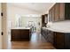 Spacious kitchen with dark wood cabinets, stainless steel appliances, and a white island at 7745 Radcliff St, Las Vegas, NV 89123