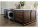 A kitchen island in dark wood with white countertops and stainless steel appliances at 7745 Radcliff St, Las Vegas, NV 89123