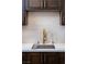 Close up on a modern kitchen sink with a gold faucet and white subway tile backsplash at 7745 Radcliff St, Las Vegas, NV 89123