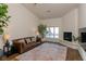 Bright living room with a fireplace, dark leather couch and stylish area rug at 7745 Radcliff St, Las Vegas, NV 89123