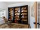 Office space features a dark wood bookshelf, patterned rug, a comfortable chair, and a large window at 7745 Radcliff St, Las Vegas, NV 89123