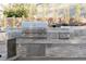 Outdoor kitchen area with stainless steel grill, granite countertops, and stone accent wall at 7745 Radcliff St, Las Vegas, NV 89123