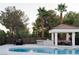 Backyard features a pool, outdoor kitchen, dining table, and covered lounge area at 7745 Radcliff St, Las Vegas, NV 89123