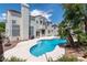 The backyard features a pool, steps leading up to the pool and trees providing shade and privacy at 8113 Blue Cascade Ave, Las Vegas, NV 89128