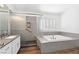 Bathroom featuring a soaking tub, a glass-enclosed shower, and double sinks with granite countertops at 8113 Blue Cascade Ave, Las Vegas, NV 89128