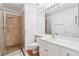 Modern bathroom featuring tiled shower, single vanity, and a large mirror with ample lighting at 8113 Blue Cascade Ave, Las Vegas, NV 89128