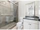 Modern bathroom featuring gray tiled shower, toilet, and vanity at 8840 Harvest Sunset St, Las Vegas, NV 89113