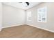 Bright bedroom featuring wood-look floors and two windows at 8840 Harvest Sunset St, Las Vegas, NV 89113