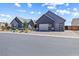 A modern gray home showcasing a paved driveway leading to a garage with unique glass panels at 8840 Harvest Sunset St, Las Vegas, NV 89113