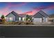 Beautiful single-story home at dusk with a manicured front yard and a three-car garage at 8840 Harvest Sunset St, Las Vegas, NV 89113