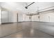 Spacious garage with epoxy flooring, storage cabinets, and multiple overhead doors at 8840 Harvest Sunset St, Las Vegas, NV 89113