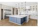 Spacious kitchen with a large waterfall island, stainless steel appliances, and custom cabinets at 8840 Harvest Sunset St, Las Vegas, NV 89113