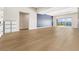 Bright living room with wood-look tile flooring and sliding glass doors to outdoor pool area at 8840 Harvest Sunset St, Las Vegas, NV 89113
