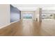 Open-concept living space with wood flooring, modern lighting, and floor-to-ceiling glass doors to the pool at 8840 Harvest Sunset St, Las Vegas, NV 89113