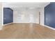 Minimalist living room featuring wood-look floors and views of the front entrance at 8840 Harvest Sunset St, Las Vegas, NV 89113