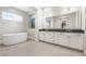 A bright primary bathroom featuring dual sinks, a soaking tub, and modern fixtures at 8840 Harvest Sunset St, Las Vegas, NV 89113