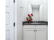 Charming powder room with a vanity, decorative flowers, and a mirror at 8840 Harvest Sunset St, Las Vegas, NV 89113