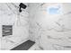 Modern shower with white marble tile and a built-in shower bench at 8840 Harvest Sunset St, Las Vegas, NV 89113