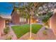 A backyard featuring artificial turf, desert landscaping, and mature shade trees at 928 Riverlawn Pl, Las Vegas, NV 89138