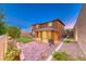 Spacious backyard with artificial turf, brick patio, and landscaping against the two-story home at 928 Riverlawn Pl, Las Vegas, NV 89138