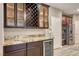 Elegant bar area with wine storage, granite countertop, and stainless steel wine refrigerator at 928 Riverlawn Pl, Las Vegas, NV 89138