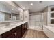 A modern bathroom features dual sinks, a large mirror, and a glass enclosed shower with a separate soaking tub at 928 Riverlawn Pl, Las Vegas, NV 89138