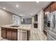 Bright kitchen with island, stone counters, stainless appliances, view of the dining and living area with plantation shutters at 928 Riverlawn Pl, Las Vegas, NV 89138