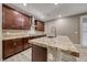 Modern kitchen featuring dark wood cabinetry, granite countertops, a large island and stainless steel appliances at 928 Riverlawn Pl, Las Vegas, NV 89138