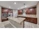 Modern kitchen featuring dark wood cabinetry, granite countertops, a large island and stainless steel appliances at 928 Riverlawn Pl, Las Vegas, NV 89138