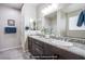 Bathroom vanity with granite countertops, dual sinks, and sleek dark wood cabinets at 10470 Irish Cliffs Ct, Las Vegas, NV 89149