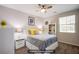 Comfortable bedroom featuring a ceiling fan, large window, and neutral decor at 10470 Irish Cliffs Ct, Las Vegas, NV 89149