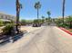 Gated entrance to a well-maintained community lined with palm trees and lush landscaping at 10553 Pine Glen Ave # 101, Las Vegas, NV 89144