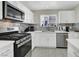 Modern kitchen featuring stainless steel appliances, white cabinetry, and tile backsplash at 10553 Pine Glen Ave # 101, Las Vegas, NV 89144
