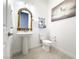Bathroom features a pedestal sink, an ornate mirror, toilet, and modern artwork at 146 Cabo Cruces Dr, Henderson, NV 89011
