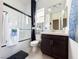 Modern bathroom featuring a shower over the bath, dark wood cabinet and grey color scheme at 146 Cabo Cruces Dr, Henderson, NV 89011