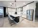 A modern kitchen features an island with seating, stainless steel appliances and sleek white cabinetry at 146 Cabo Cruces Dr, Henderson, NV 89011
