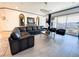 A spacious living room features a modern chandelier, a large leather sofa, and a sliding glass door at 146 Cabo Cruces Dr, Henderson, NV 89011
