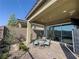 Covered patio featuring a seating area, brick pavers, landscaping, and mountain views through sliding glass doors at 146 Cabo Cruces Dr, Henderson, NV 89011