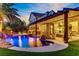 Backyard with pool, outdoor kitchen, and patio, perfect for outdoor living and entertaining, surrounded by lush palm trees at 1509 Winslow St, Las Vegas, NV 89117