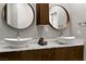 Bathroom featuring double vessel sinks, stone countertops, modern cabinets, and round decorative mirrors at 1509 Winslow St, Las Vegas, NV 89117